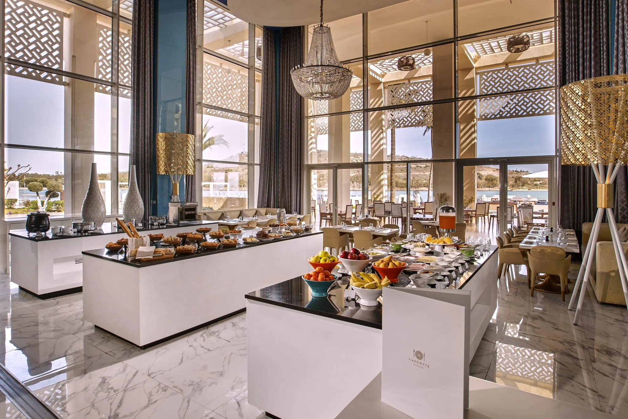 Restaurant élégant avec buffet de petit-déjeuner, grandes fenêtres et vue sur la mer